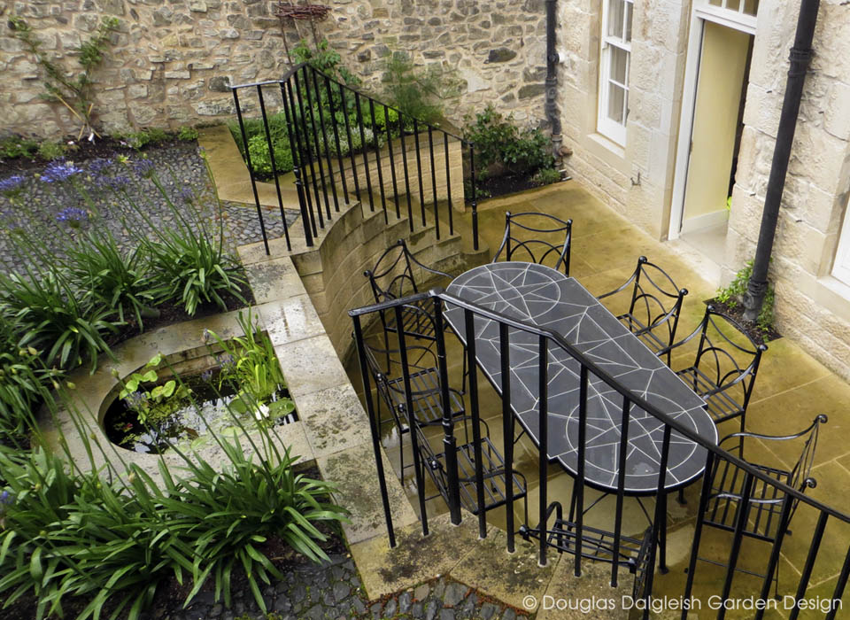 pond with slate and wrought iron table on patio