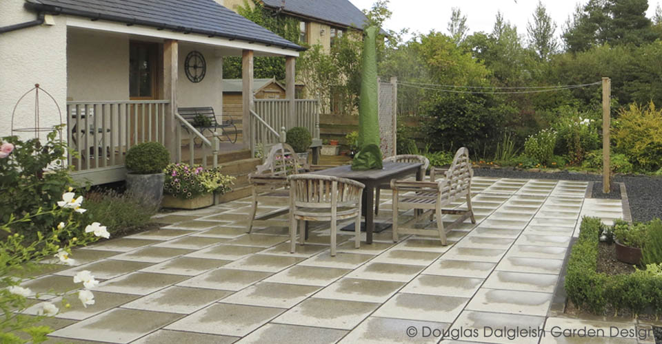 paved patio with table, chairs, benches